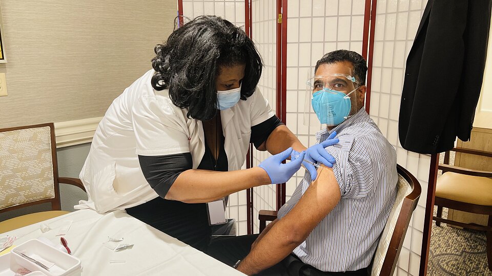 photo of abraham mathew the executive director of parkway place receiving vaccine