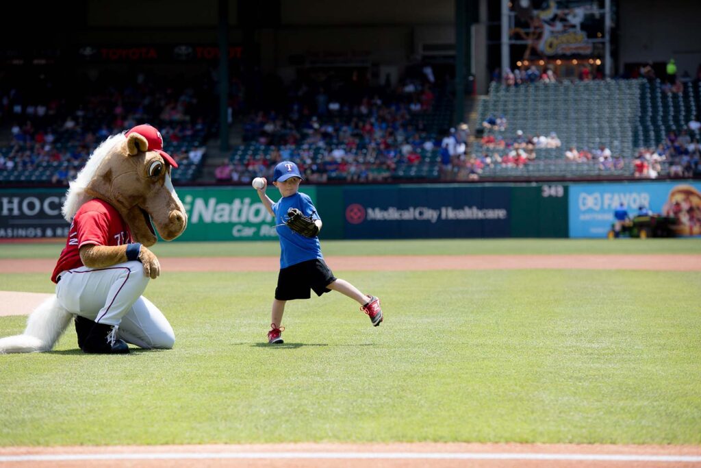 adopted-child-through-buckner-international-throws-first-pitch-at-texas-rangers-game