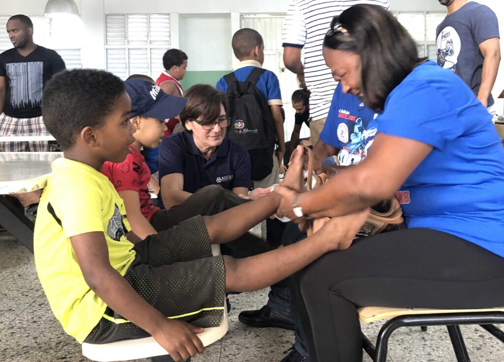 adrian-beltres-mother-places-shoes-on-a-child-s-feet