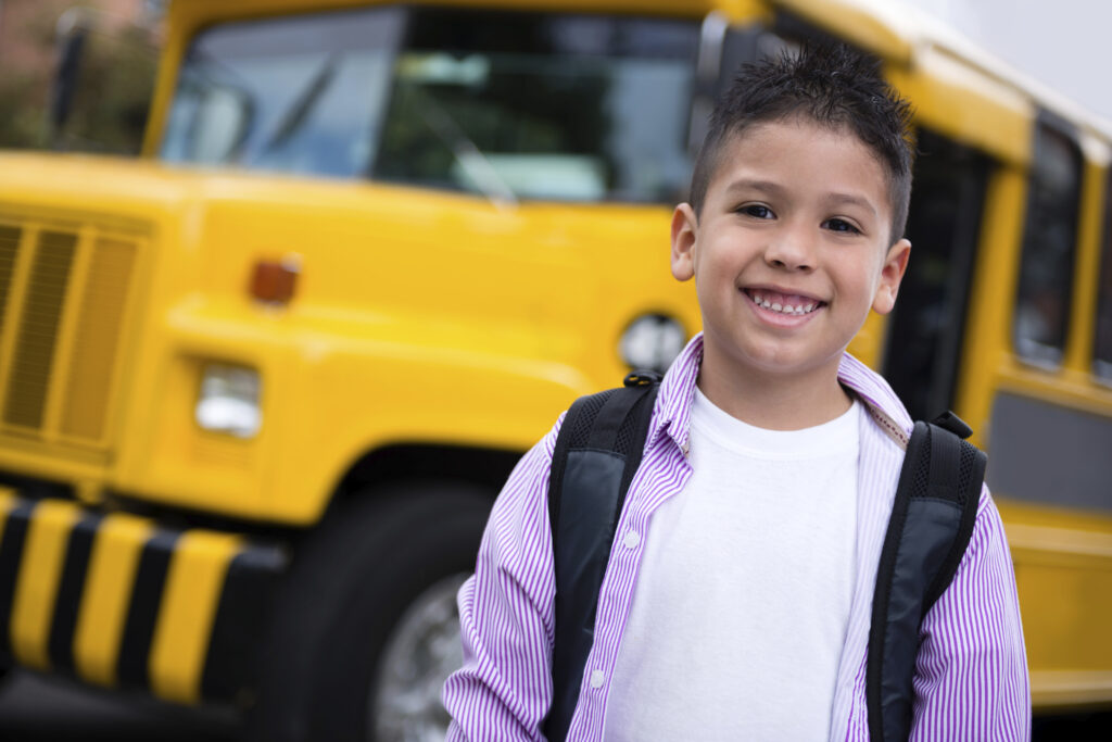 Happy boy going to school by bus