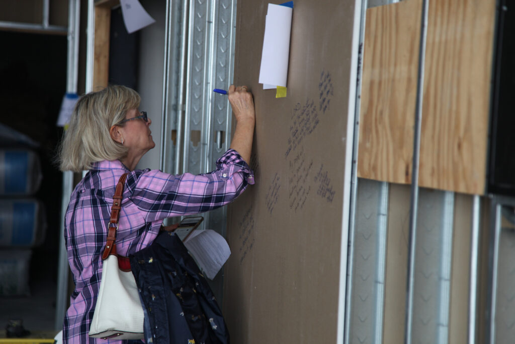 friends-of-buckner-write-blessings-on-the-family-hope-center-walls