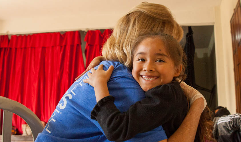 volunteer-hugging-child
