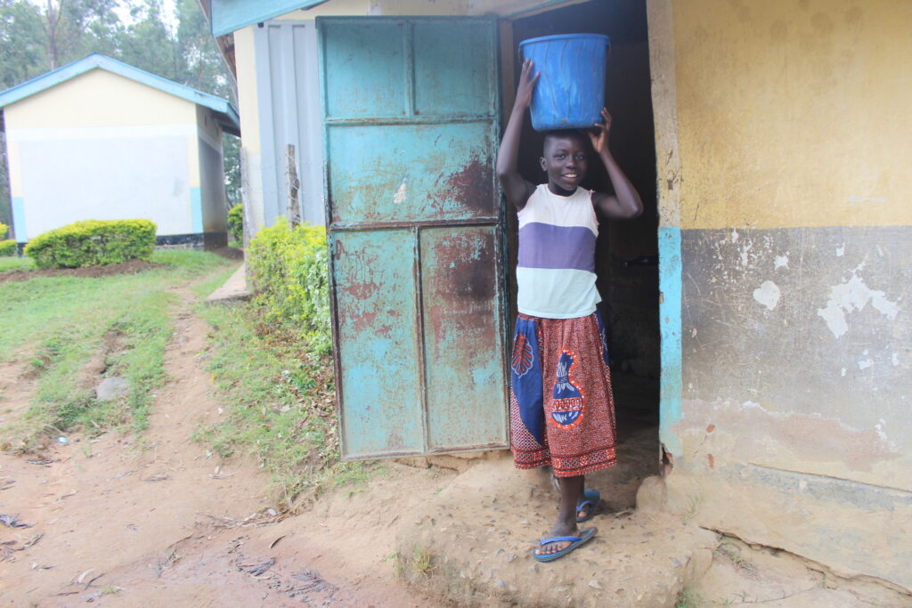 Cynthia carrying water from the pump