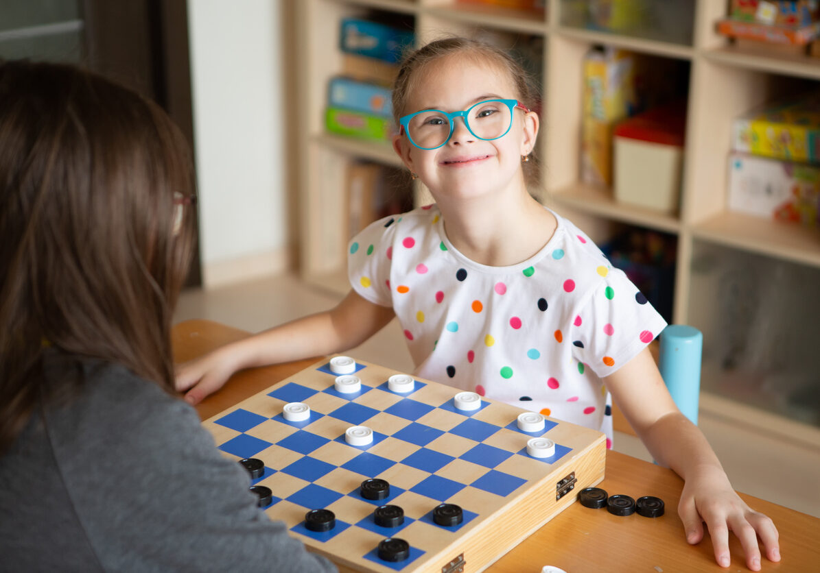 Girl with Down Syndrome Plays Checkers with Her Sister in Quarantine